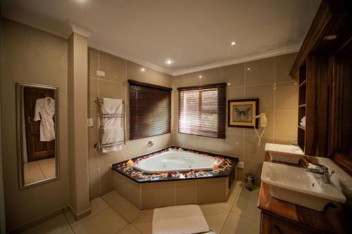 ein Badezimmer mit einer Badewanne, einem Fenster und einem Waschbecken in der Unterkunft Fairview Hotels,Spa & Golf Resort in Tzaneen