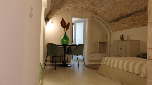 a bedroom with a bed and a table and chairs at Le Badesse Mitrate by il pumo di puglia in Conversano