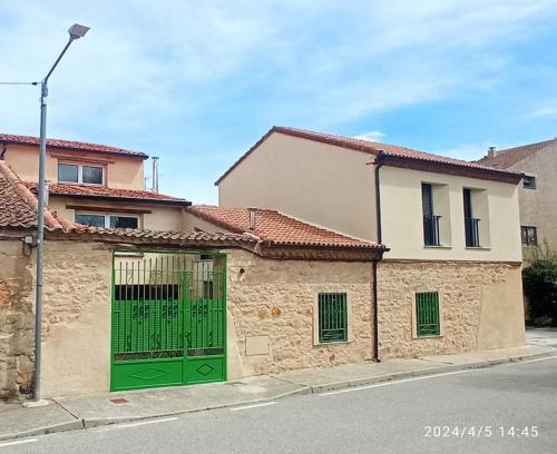 un bâtiment avec une porte verte dans une rue dans l'établissement Casa Rural - De Brevas a Higos, à Espirdo