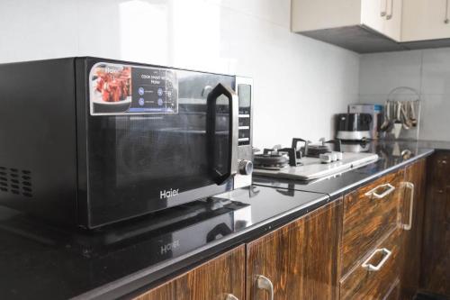 a microwave oven sitting on top of a kitchen counter at Vista Valle in Murree