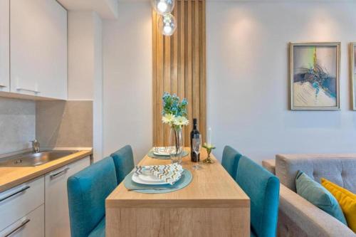 uma cozinha com uma mesa e cadeiras azuis em EMA LUX - zgrada Panorama em Sokobanja