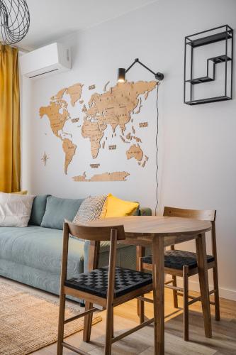 a living room with a table and a world map on the wall at RentPlanet - Apartamenty Zarembowicza in Wrocław