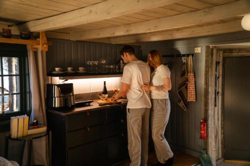 Ein Mann und eine Frau stehen in einer Küche in der Unterkunft Stabbur med fantastisk utsikt! in Steinkjer