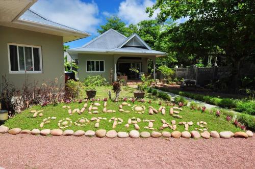 a sign written in the grass in front of a house at Cote d'Or Footprints in Baie Sainte Anne