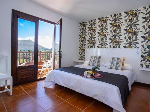 ein Schlafzimmer mit einem Bett und einem Balkon in der Unterkunft Villa Verol La Vegueta Villas in Tinajo