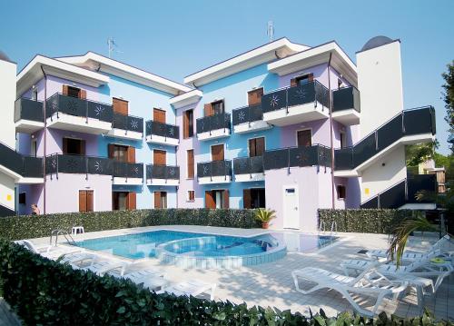 un edificio con piscina frente a él en Residence Acquarium en Bibione