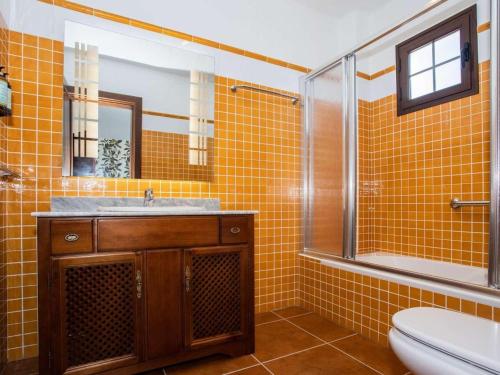 ein gelb gefliestes Bad mit einem Waschbecken und einem WC in der Unterkunft Villa Verol La Vegueta Villas in Tinajo
