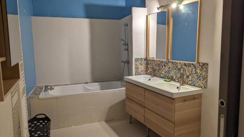 une salle de bain avec une baignoire et un lavabo et une baignoire dans l'établissement Chez Jeanne, à Marseillan