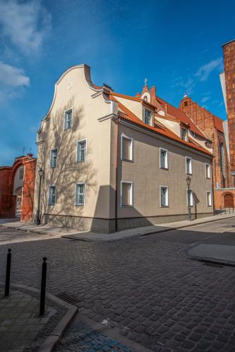 a large building with a red roof on a street at Soul House Gdansk Old Town in Gdańsk