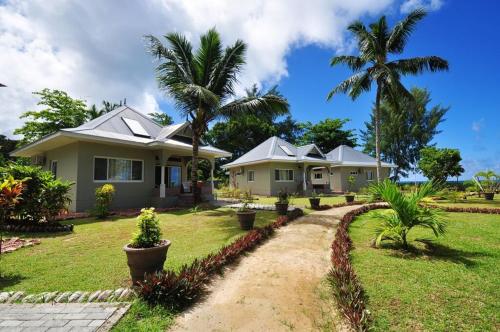 a house with palm trees in a yard at Cote d'Or Footprints in Baie Sainte Anne