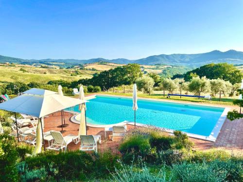 een zwembad met parasols en stoelen en een zwembad bij La Toscavera - I Tre Archi in Pomarance