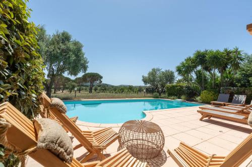 une piscine avec deux transats et une table dans l'établissement VILLA NIKKi, à Saint-Tropez