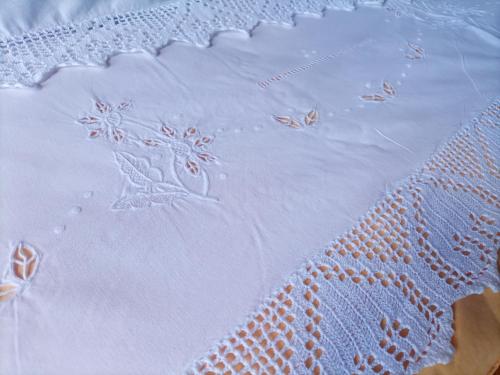 a close up of a white table cloth with flowers on it at Casetta dei Nonni in Vitorchiano