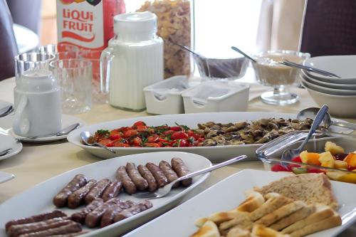 Oasis Of Life Guest House في ويتبانك: طاولة عليها ثلاثة أطباق من الطعام