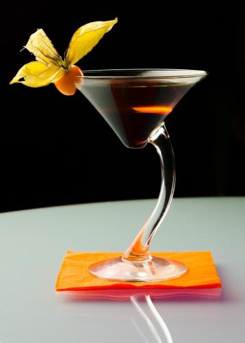 a drink in a glass with a flower in it at Simbad Hotel & Bar Superior in Mosonmagyaróvár