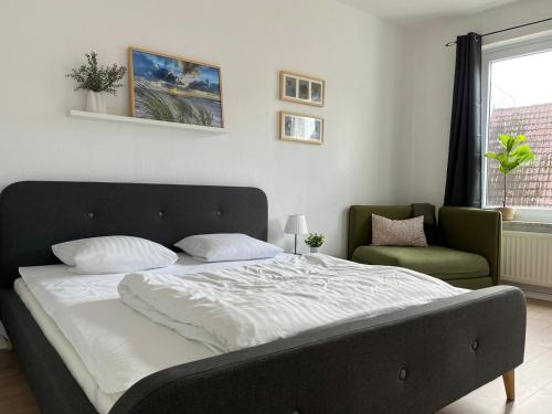 um quarto com uma cama, uma cadeira e uma janela em Koje St. Jürgen Treppe em Flensburg