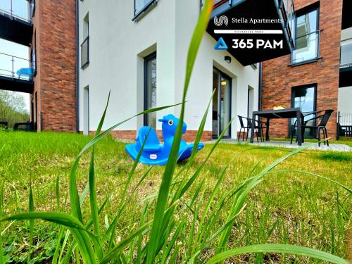 a blue toy in the grass in front of a building at Apartament Różana Polana z Ogrodem - 365PAM in Sianozety