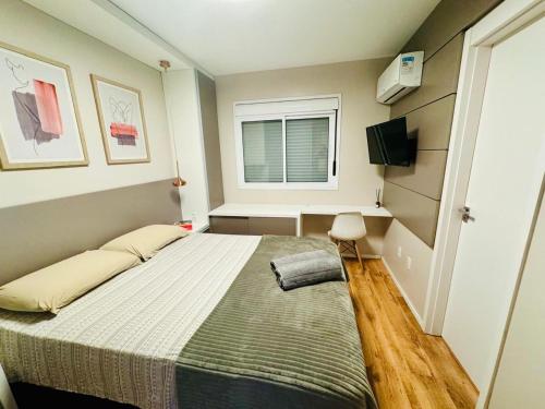 a small bedroom with a bed and a window at Apartamento Acqua, 102 A, com vaga de garagem in Pelotas