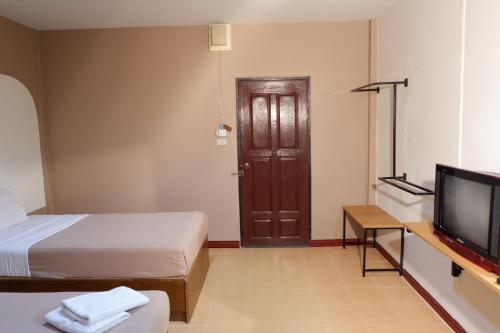 um quarto com duas camas e uma televisão e uma porta em กิจตรงวิลล์ รีสอร์ท Kittrongvill em Ubon Ratchathani