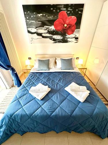 a bedroom with a blue bed with a red flower on the wall at Giardino al mare in Rimini