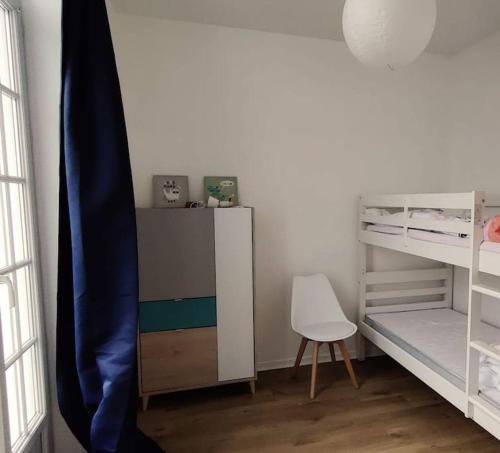 - une chambre avec des lits superposés, un bureau et une chaise dans l'établissement Appartement familial lumineux, à La Rudelière