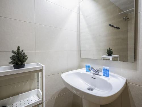 La salle de bains blanche est pourvue d'un lavabo et d'un miroir. dans l'établissement Heaven With a Garden at Las Ramblas, à Barcelone