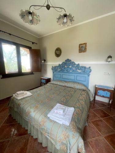 ein Schlafzimmer mit einem blauen Bett und Handtüchern darauf in der Unterkunft Azienda agrituristica Di Fiore in Morcone