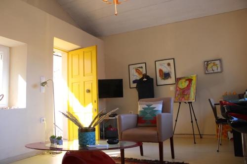 a living room with a table and a yellow door at Artistic Sea View House in Corfu