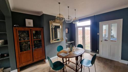 comedor con paredes azules, mesa y sillas en Inviting 2-Bed Character House Stamford, en Lincolnshire