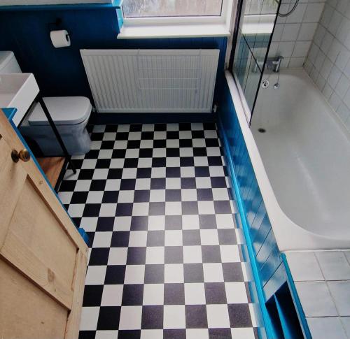 a bathroom with a black and white checkered floor at Inviting 2-Bed Character House Stamford in Lincolnshire