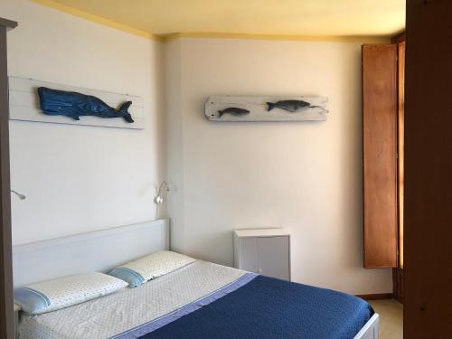 1 dormitorio con 1 cama y 2 toallas en la pared en orizzonte mare, en Teulada