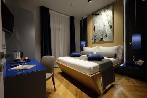Cette chambre comprend un lit avec une table bleue et un bureau. dans l'établissement Navona Rooms, à Rome