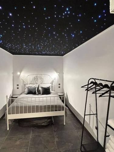 een slaapkamer met een bed met sterren op het plafond bij White Spa by Gold Spa in Roubaix