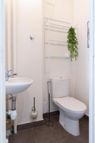 La salle de bains est pourvue de toilettes et d'un lavabo avec une plante. dans l'établissement Le Sorbier By ApiRent #Wifi #Climatisation #Lumineux, à Cannes