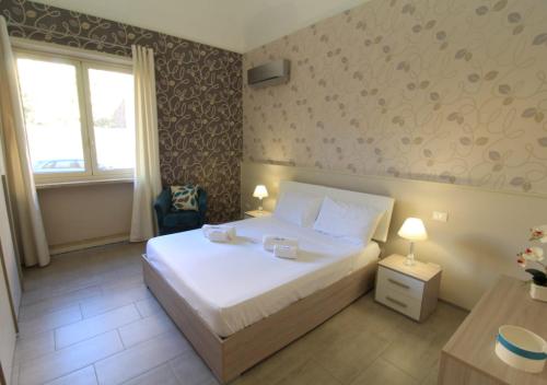 1 dormitorio con cama blanca y ventana en Appartamento Sofia, en Trapani