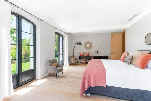 une chambre avec un grand lit et de grandes fenêtres dans l'établissement Villa Moutte, à Saint-Tropez