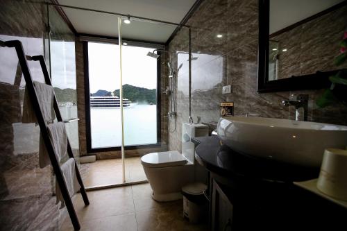 baño con lavabo y aseo y ventana en Lotus Luxury Cruise, en Ha Long