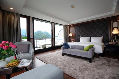 a bedroom with a king sized bed and a living room at Lotus Luxury Cruise in Ha Long