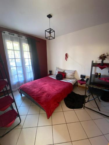 1 dormitorio con 1 cama grande con manta roja en Chambre dans maison proche Disneyland Paris, en Brie-Comte-Robert