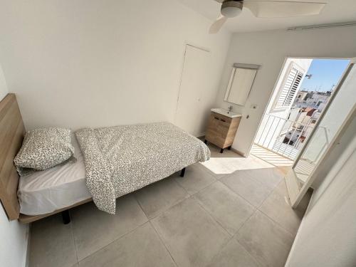 - une petite chambre avec un lit et un balcon dans l'établissement Hostal Cisne, à Sant Antoni de Portmany