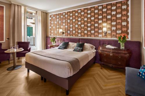 um quarto com uma cama grande e uma parede roxa em Hotel Accademia em Verona