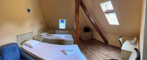 Pokój z 2 łóżkami i niebieską kanapą w obiekcie Willa Sanssouci w Kudowie Zdroju