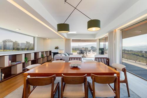 a dining room with a large wooden table and chairs at Douro Valley Luxury Home with Vineyard and Infinity Pool in Santa Marta de Penaguião