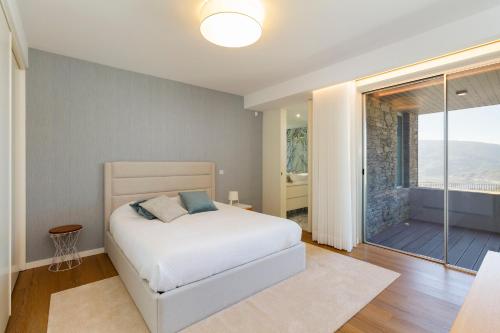 a bedroom with a bed and a sliding glass door at Douro Valley Luxury Home with Vineyard and Infinity Pool in Santa Marta de Penaguião