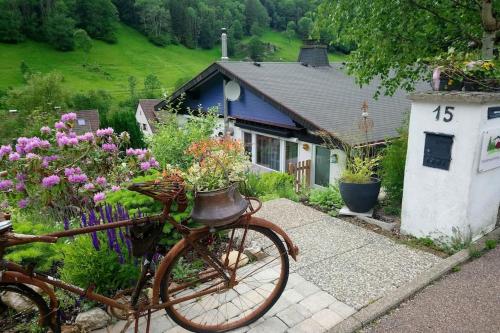 a bike parked in front of a house with flowers at Ferienwohnung Schog in Todtnau