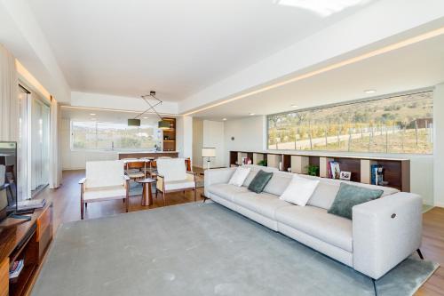 sala de estar con sofá blanco y mesa en Luxury Vineyard Home with Infinity Pool in Douro Valley, en Santa Marta de Penaguião