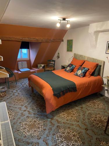 sypialnia z pomarańczowym łóżkiem i biurkiem w obiekcie Atipyk'ododo w mieście Saint-James