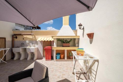 patio con divano, tavolo e lavandino di Aia Lucia B&B a Giurdignano