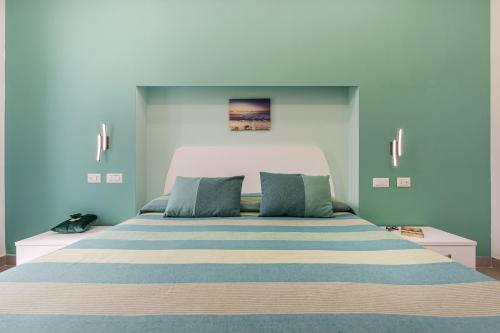 a bedroom with a large bed with blue walls at Le Rondinelle Rooms in Procida
