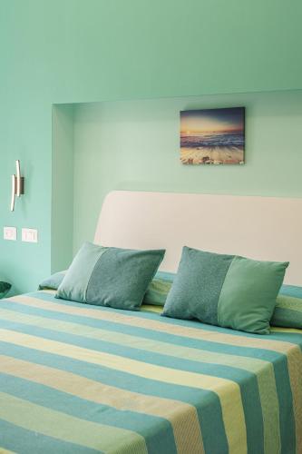 a bedroom with a large bed with a striped blanket at Le Rondinelle Rooms in Procida